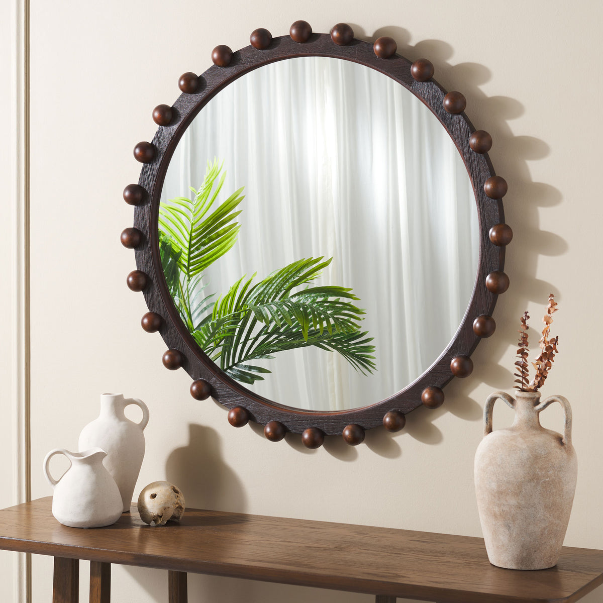 Walnut-finished round mirror with wood bead accents brings warmth to a wall above a console || MRR9026A || front_room