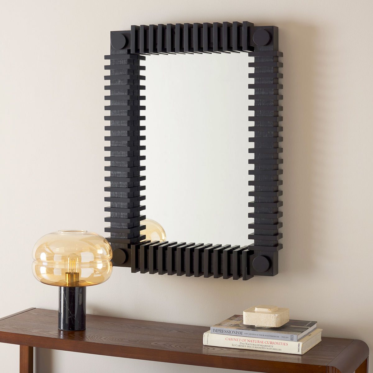 Ribbed black wall mirror brings graphic texture above a warm wood console. || MRR9037A || front_room