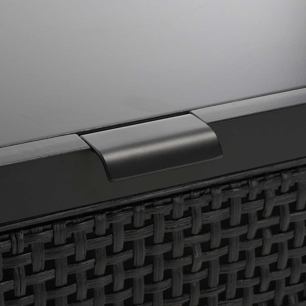 Low-profile metal pull complements the woven rattan accent in a modern black finish.