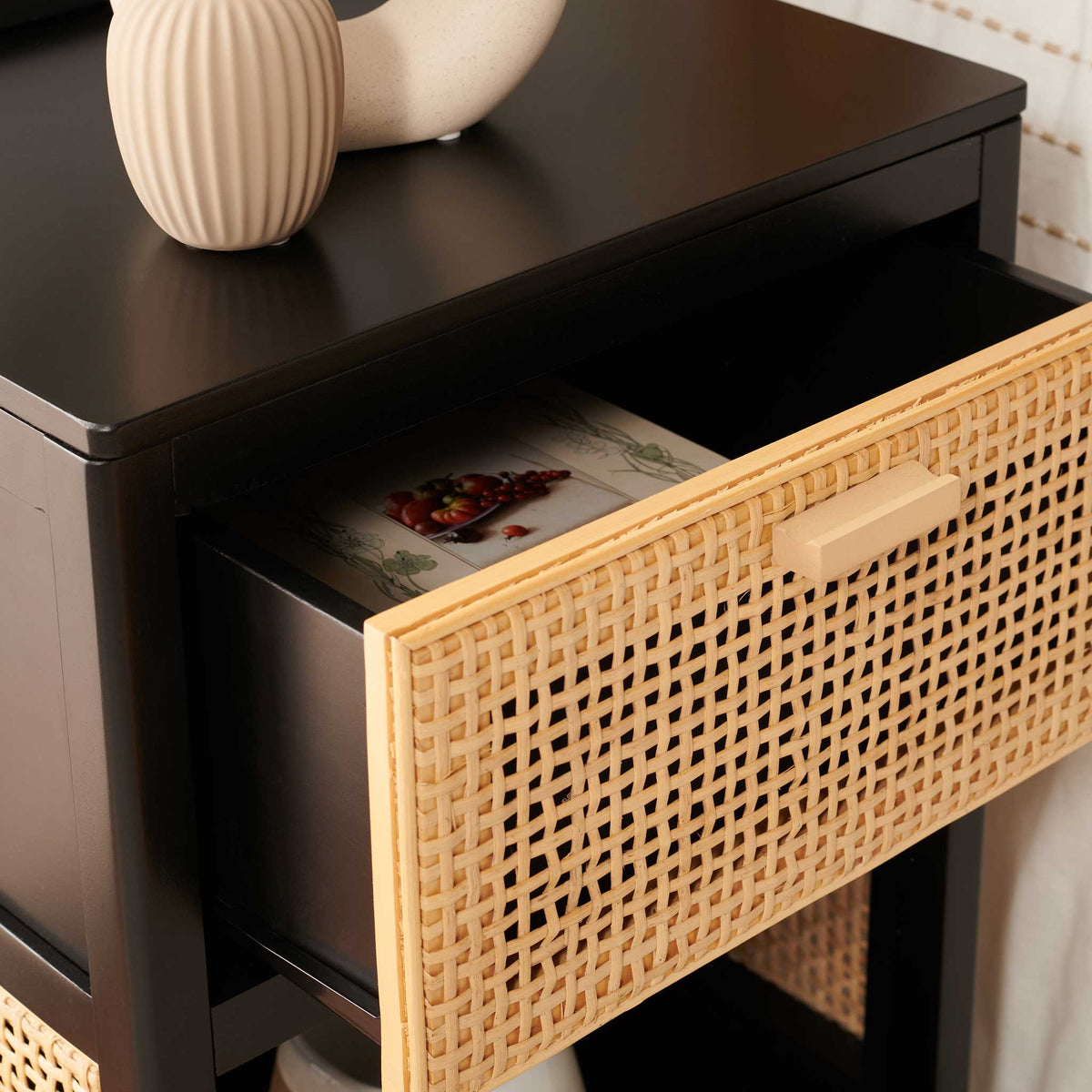 Woven cane drawer with wood pull opens to reveal a roomy interior for nighttime essentials.