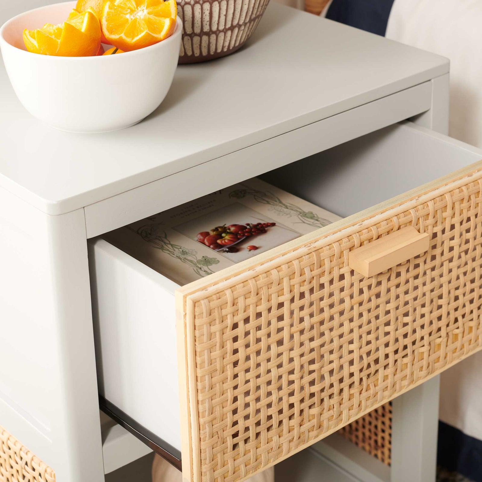 Smooth drawer glide and cane-front texture keep nightly reads and essentials neatly within reach. || NST5012D || storage_open_room