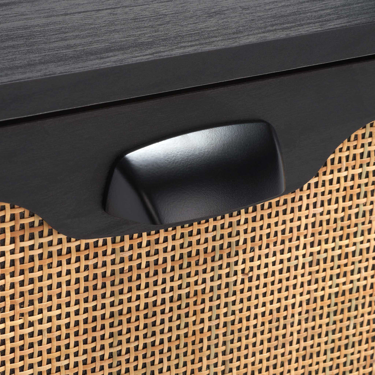 Black metal cup pull and woven rattan drawer front add warm texture and contrast