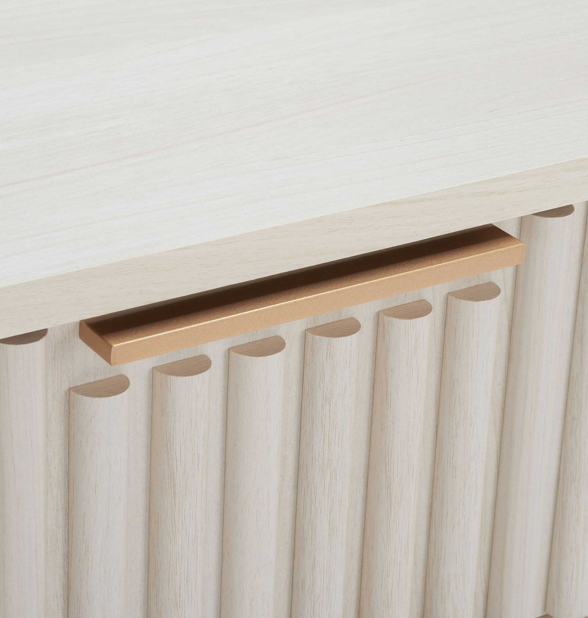 Slim gold handle adds a refined contrast to the fluted bleached white facade. || NST9605C || handle_studio