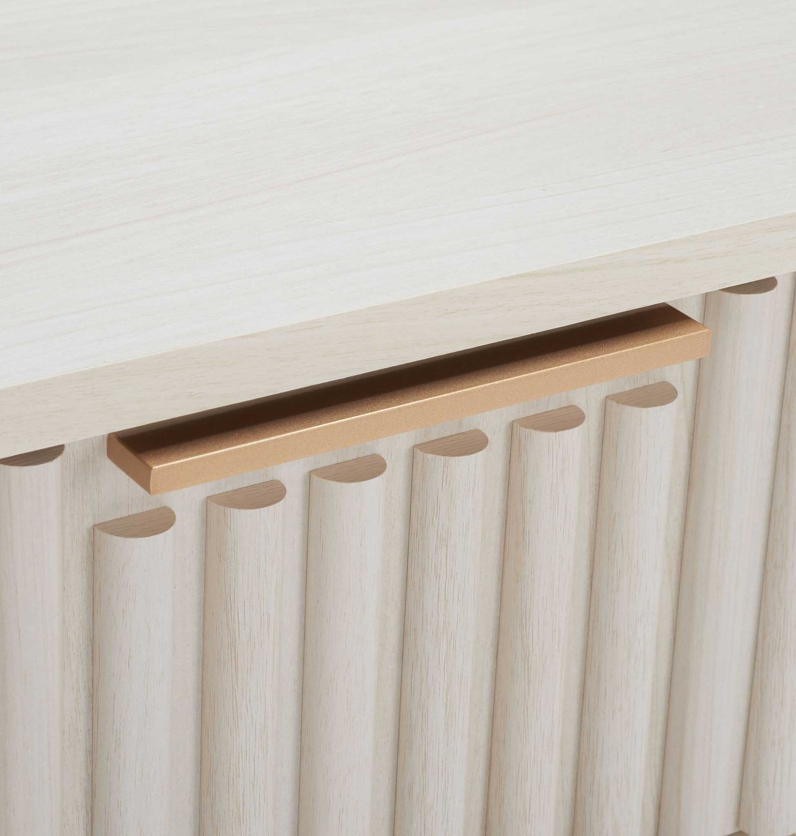 Slim gold handle adds a refined contrast to the fluted bleached white facade. || NST9605C || handle_studio