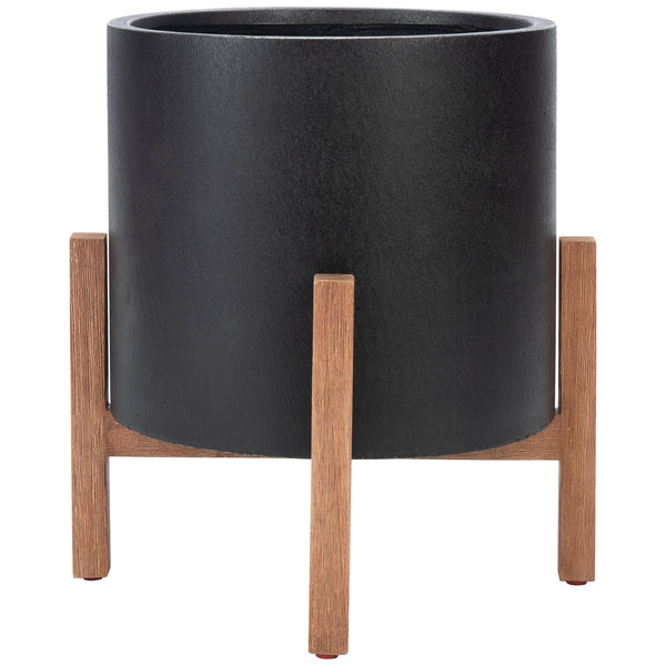 A matte black cylindrical pot rises on a warm wood-grain stand with clean, upright legs. || PAT1514A || front_studio