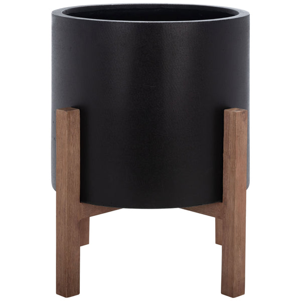 A large matte black planter lifts a roomy cylindrical vessel on a warm wood-grain frame. || PAT1515A || front_studio