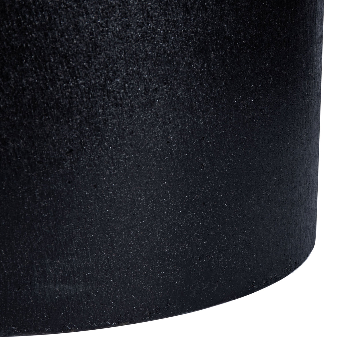 The black planter's curved lower edge carries its subtle texture to the base