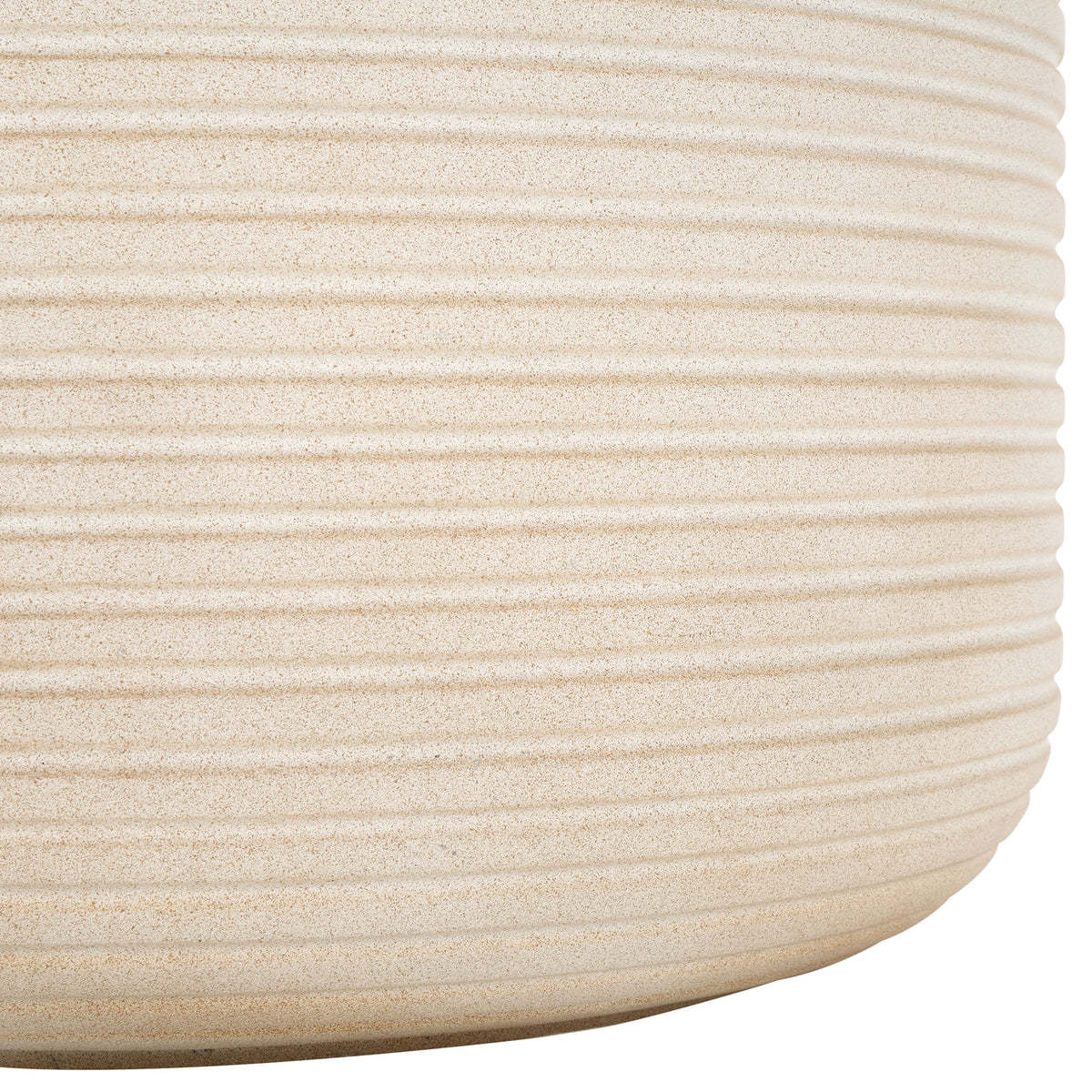 The beige planter's softly rounded base shows off its sandy finish and closely spaced ribs