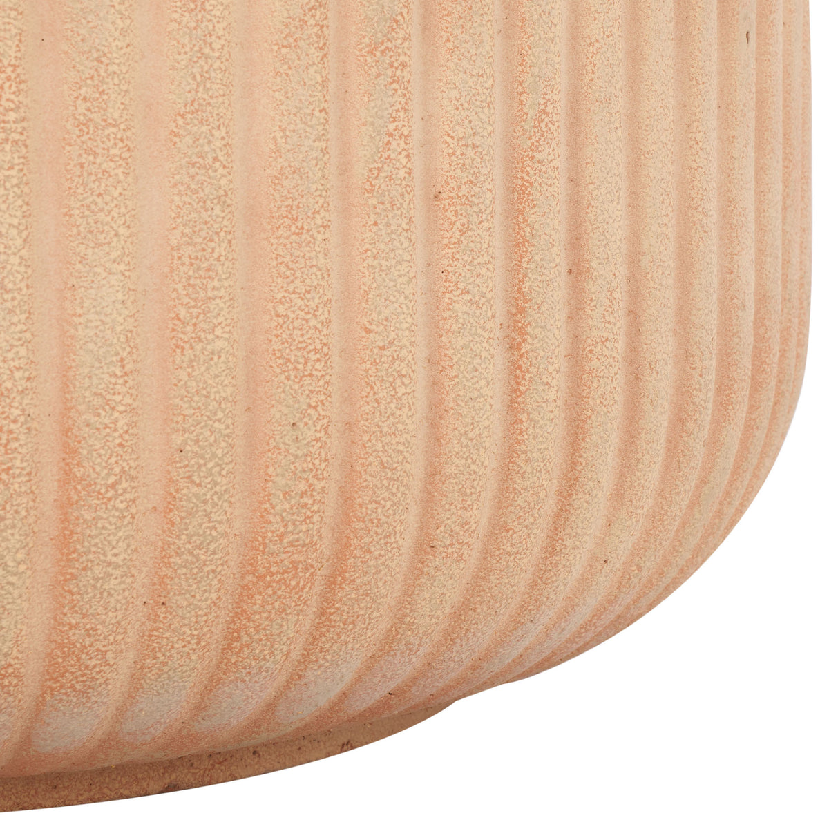 Warm terracotta fluting sweeps around the planter's gently rounded base.