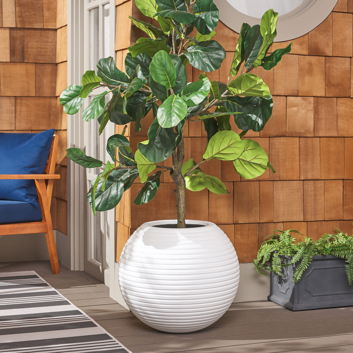Crisp white ribbed planter frames lush broad-leaf greenery with a bright, fresh finish. || PAT1534C || front_room