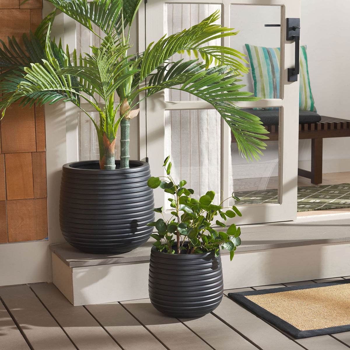 Ribbed black planters anchor leafy arrangements beside a patio doorway || PAT1535A-SET2 || front_angle_room