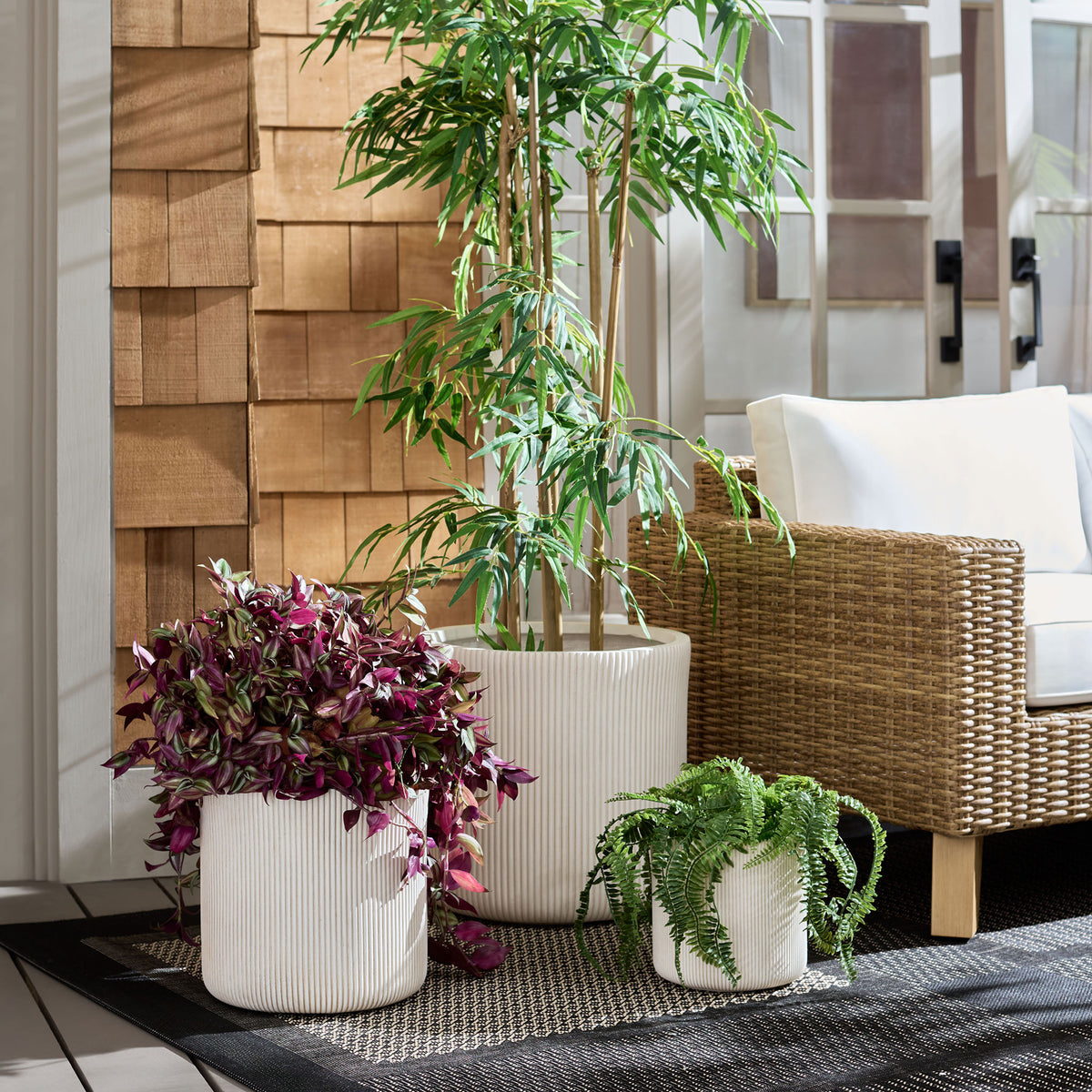 Beige ribbed planters bring layered greenery to a cozy patio seating area.