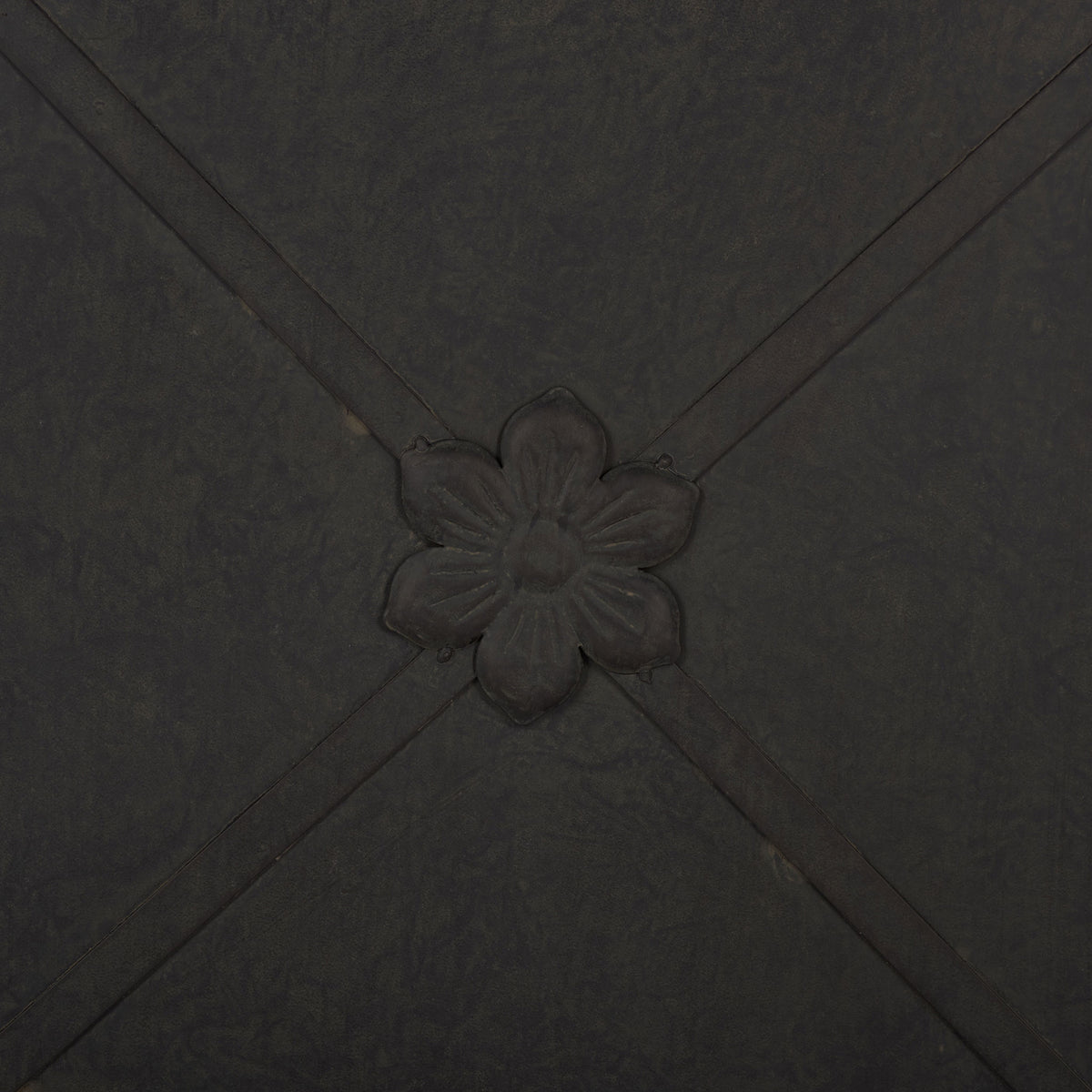 A raised flower medallion accents crossing iron bands on the black planter. || PAT5048E || detail_studio