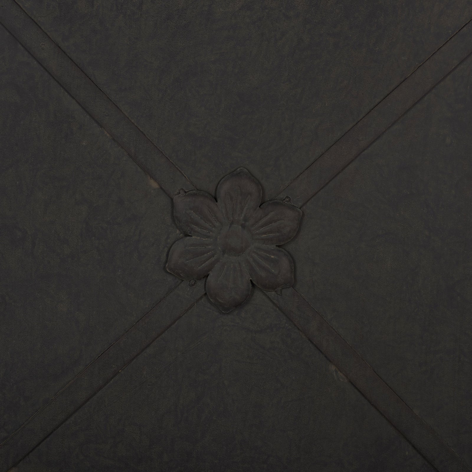 A raised flower medallion accents crossing iron bands on the black planter. || PAT5048E || detail_studio