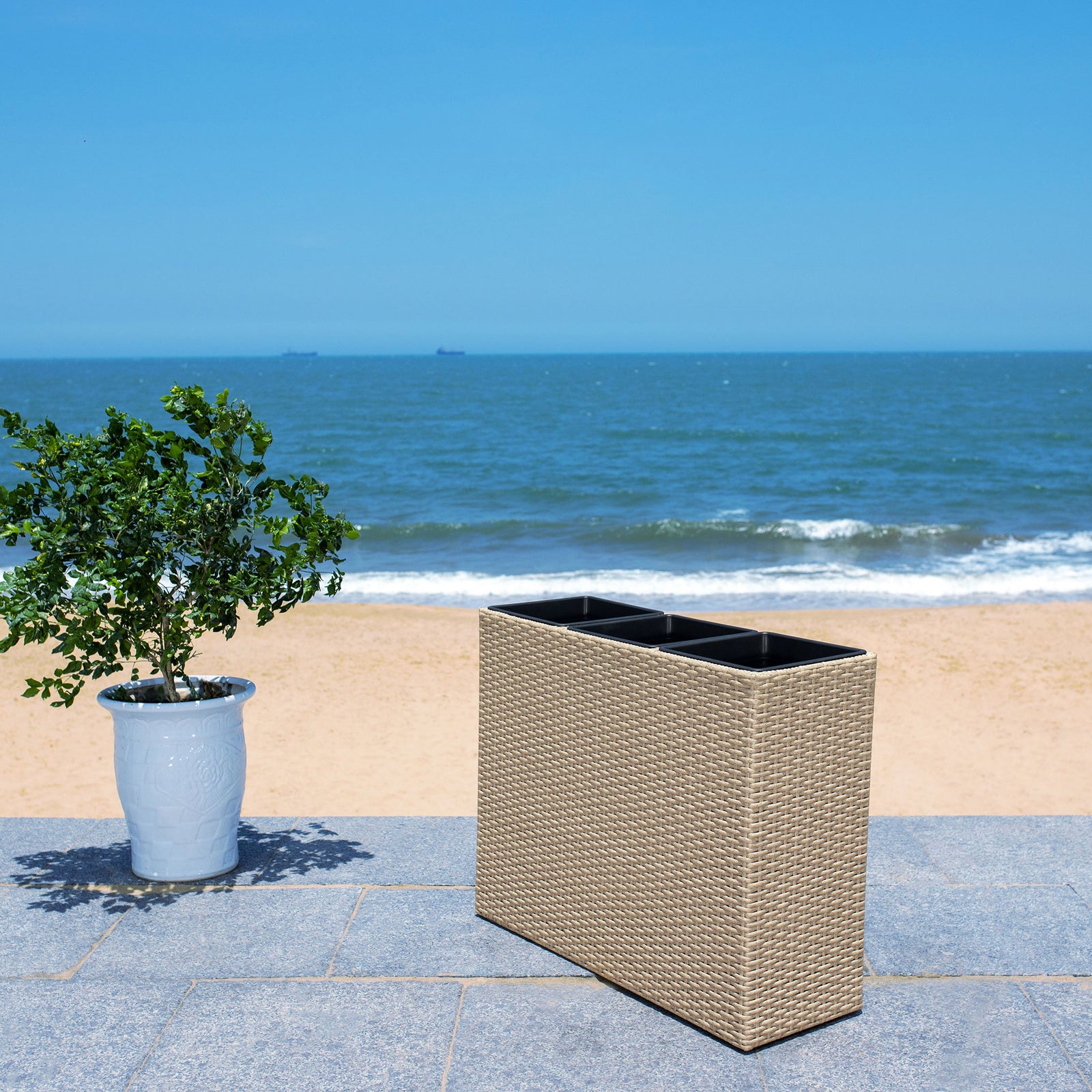 Beige woven planter makes a streamlined home for greenery beside the coast. || PAT7705B || front_angle_room