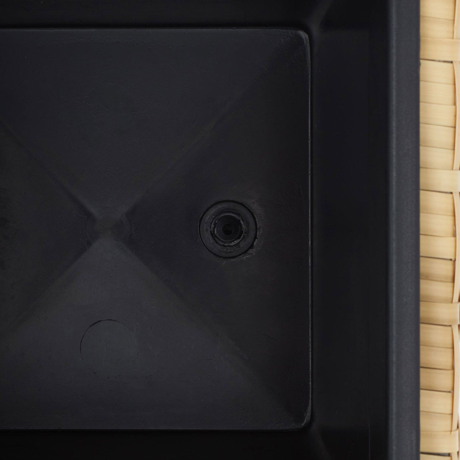 A black planting insert has a molded base with a circular drain opening. || PAT7705D || detail_studio