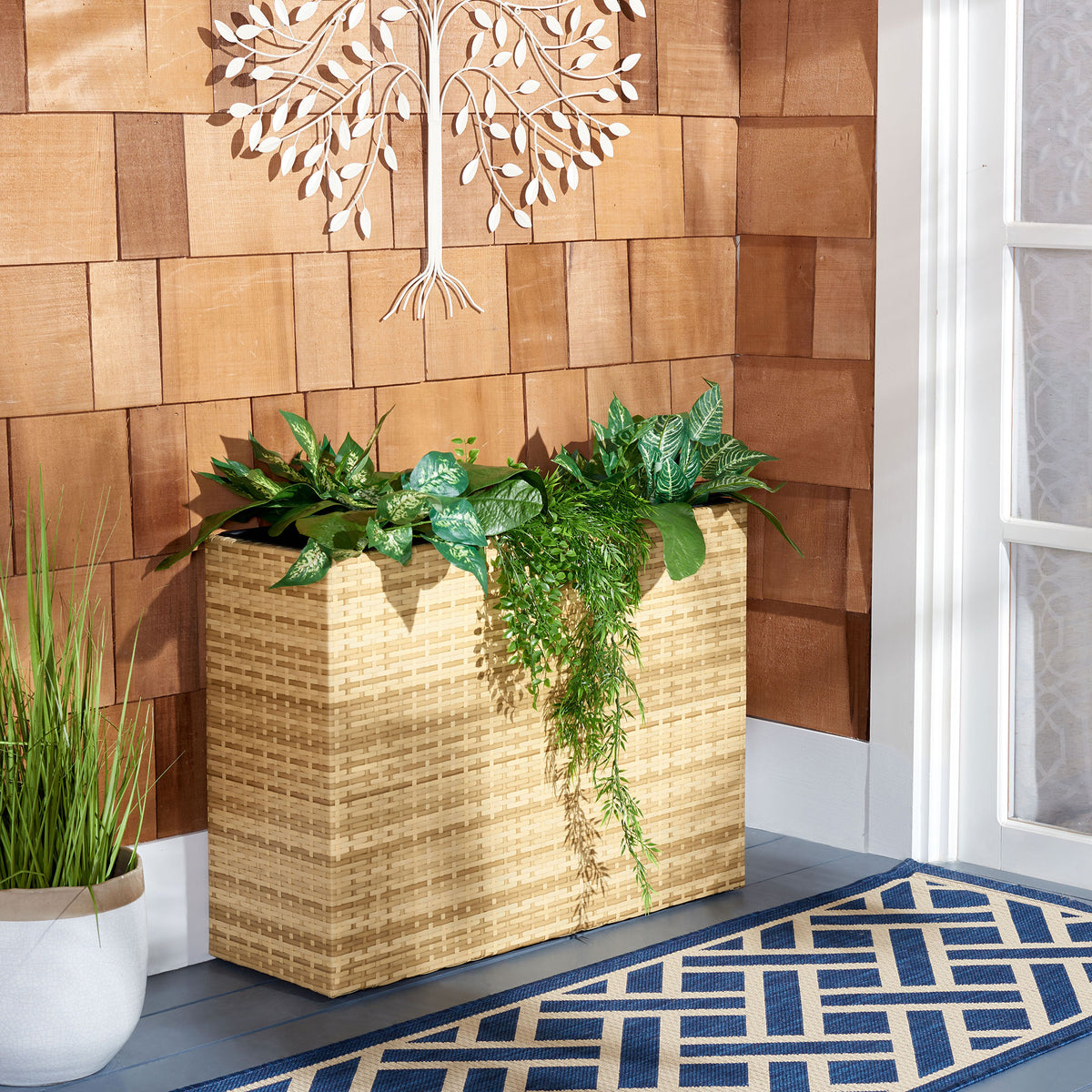 Leafy plants and trailing foliage brighten a natural-toned wicker planter. || PAT7705D || front_room