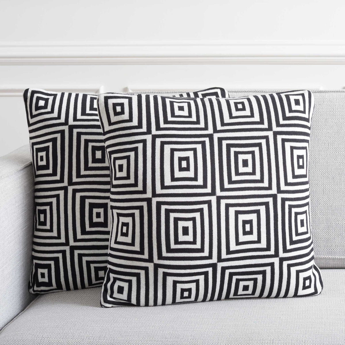 Geometric black and ivory pillows add striking contrast on a light sofa for a chic, contemporary look. || PLS402A-1818-SET2 || front_multi_room