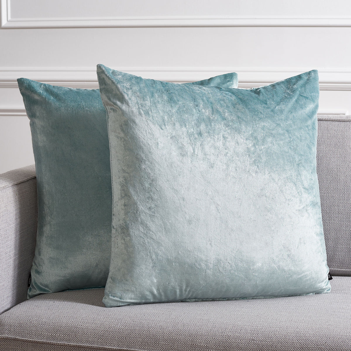Two roomy aqua pillows brighten a gray sofa with soft color and a velvety glow. || PLS500B-2222-SET2 || front_multi_room