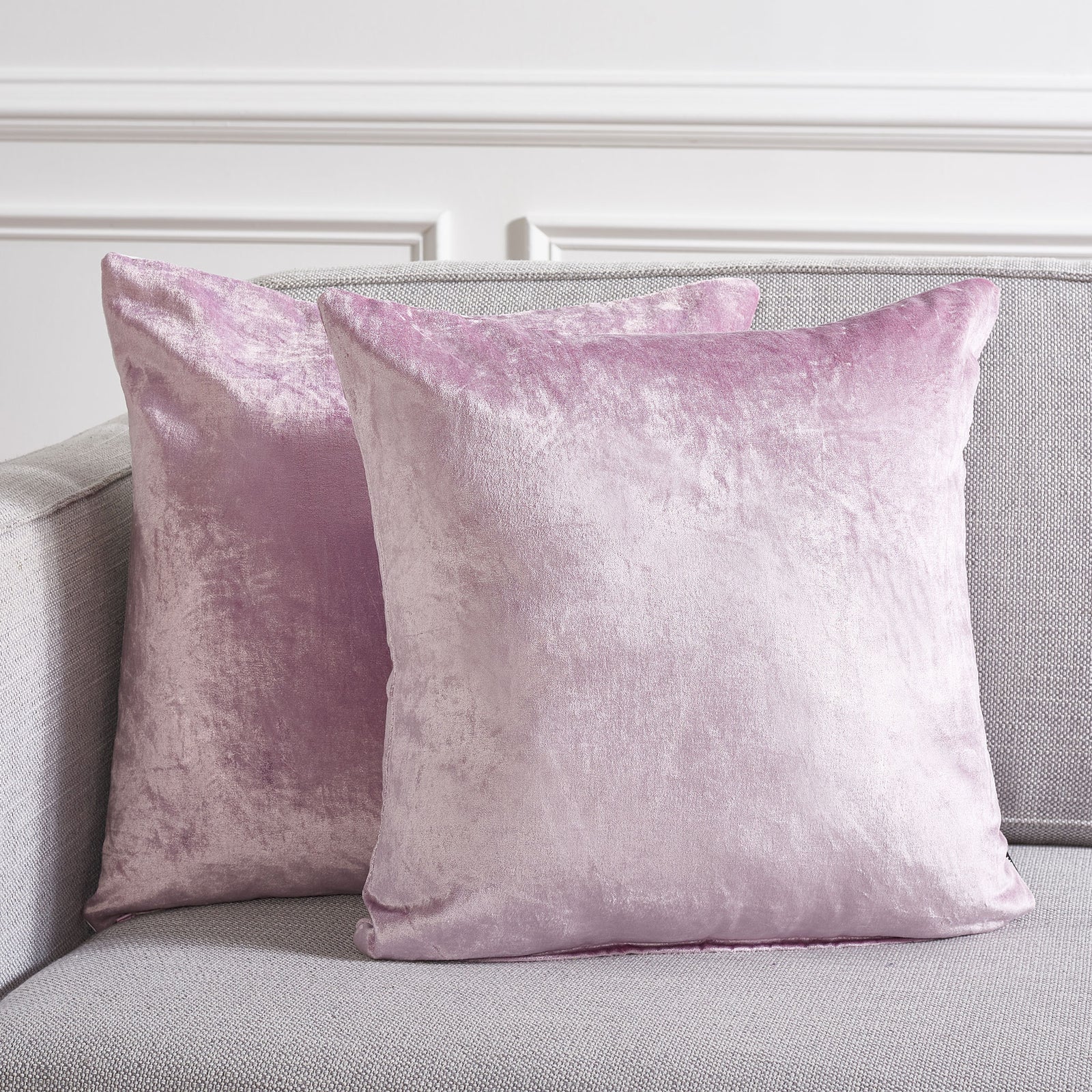 Two plush lavender pillows bring a serene hint of color to a light gray sofa. || PLS500D-1818-SET2 || front_multi_room