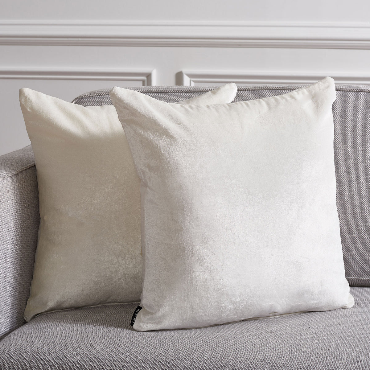 A pair of ivory pillows adds soft texture and a warm glow to a gray sofa || PLS503A-1818-SET2 || front_multi_room