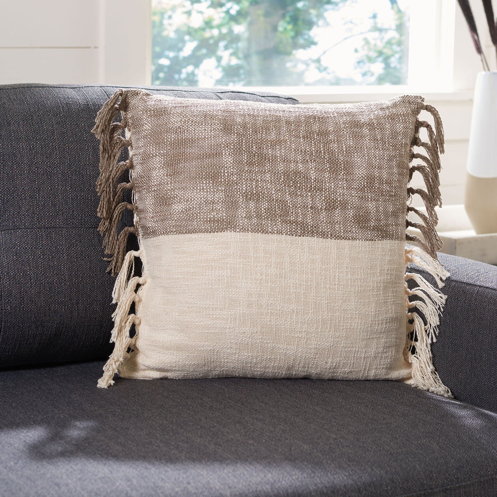 Two-tone woven pillow with long side tassels adds warmth to a dark sofa || PLS6532A-1818 || front_room