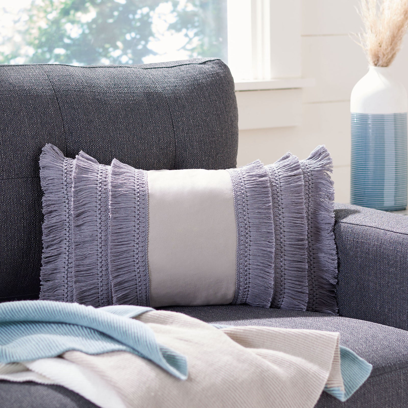 Periwinkle fringe and a pale center panel bring soft texture to this sofa accent pillow. || PLS7142F-1220 || front_room