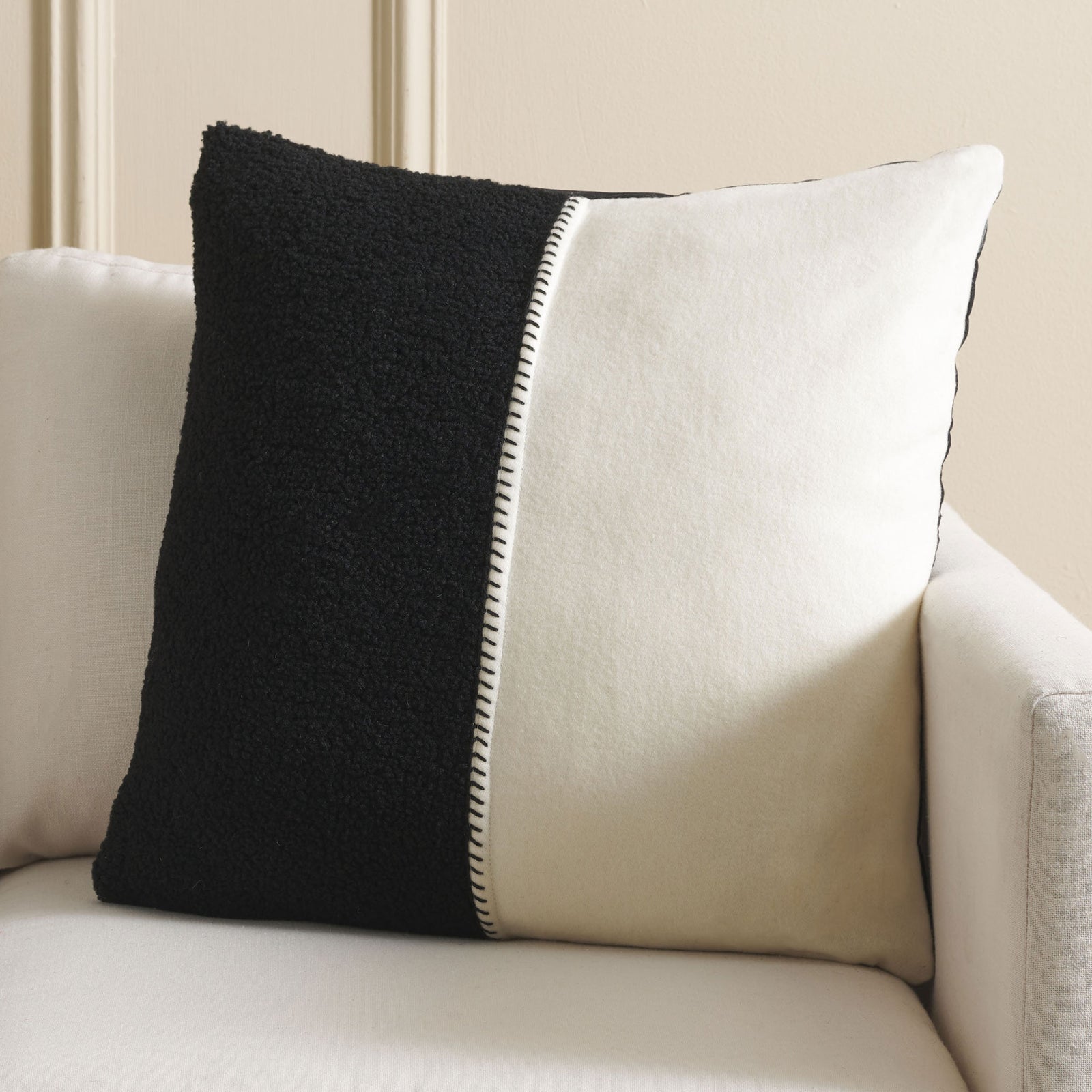 Black and ivory pillow pairs plush texture with crisp color blocking on a light sofa. || PLS7221A-2020 || front_room