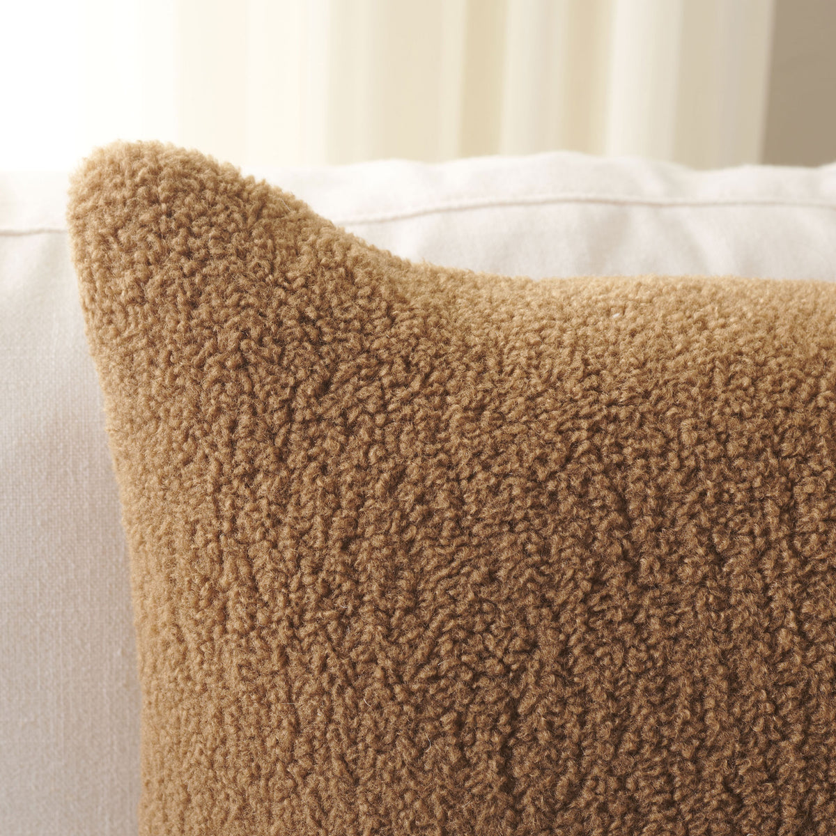 Camel-colored nubby fabric gives the pillow a plush, inviting texture.