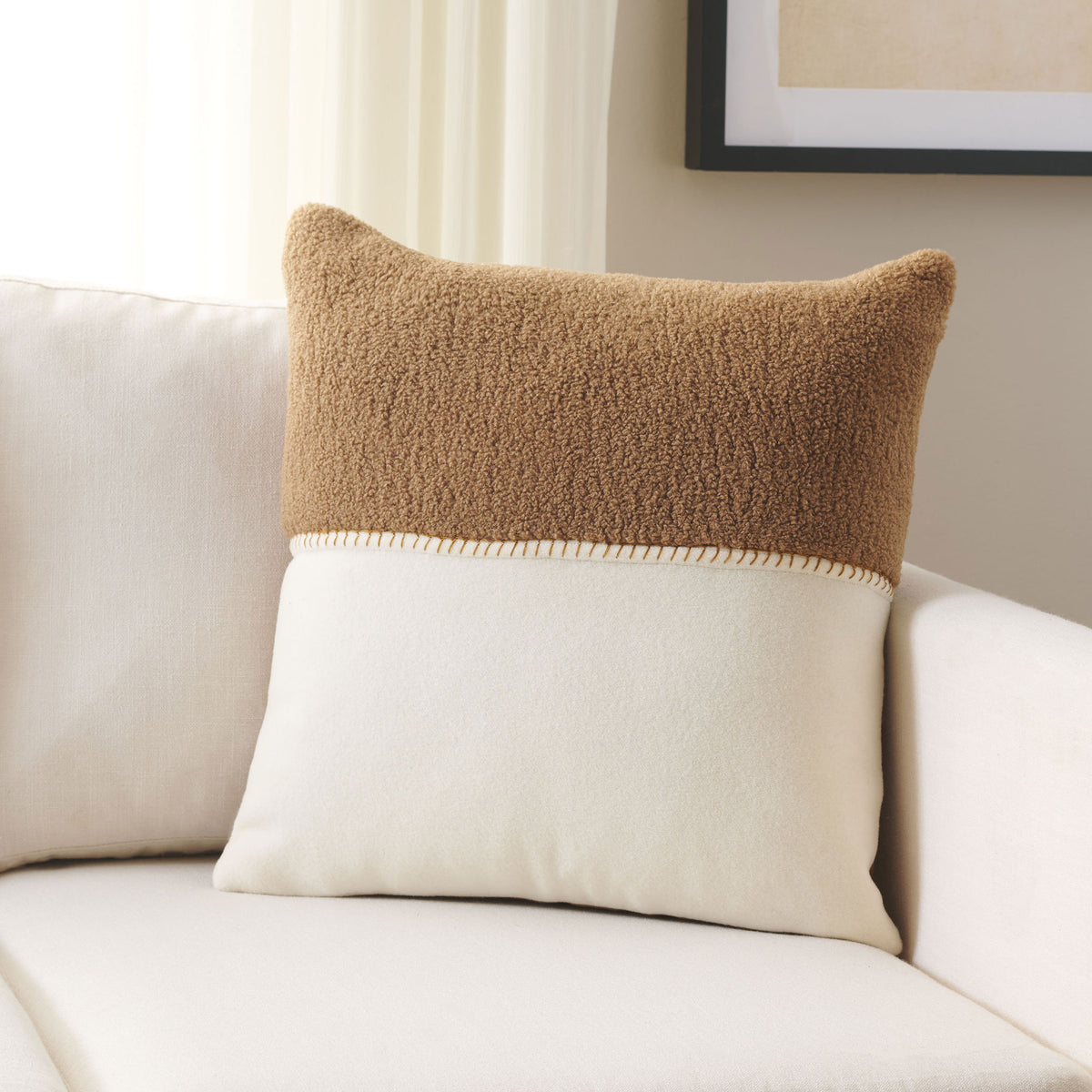 Camel and ivory panels bring warm contrast and soft texture to a pillow on a light sofa. || PLS7221B-2020 || front_room