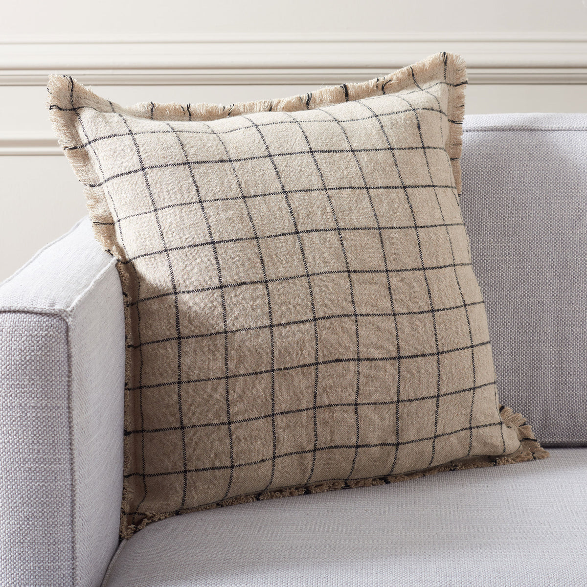 A neutral checked linen pillow adds tailored pattern and soft fringe to a sofa || PLS8005A-2020 || front_room