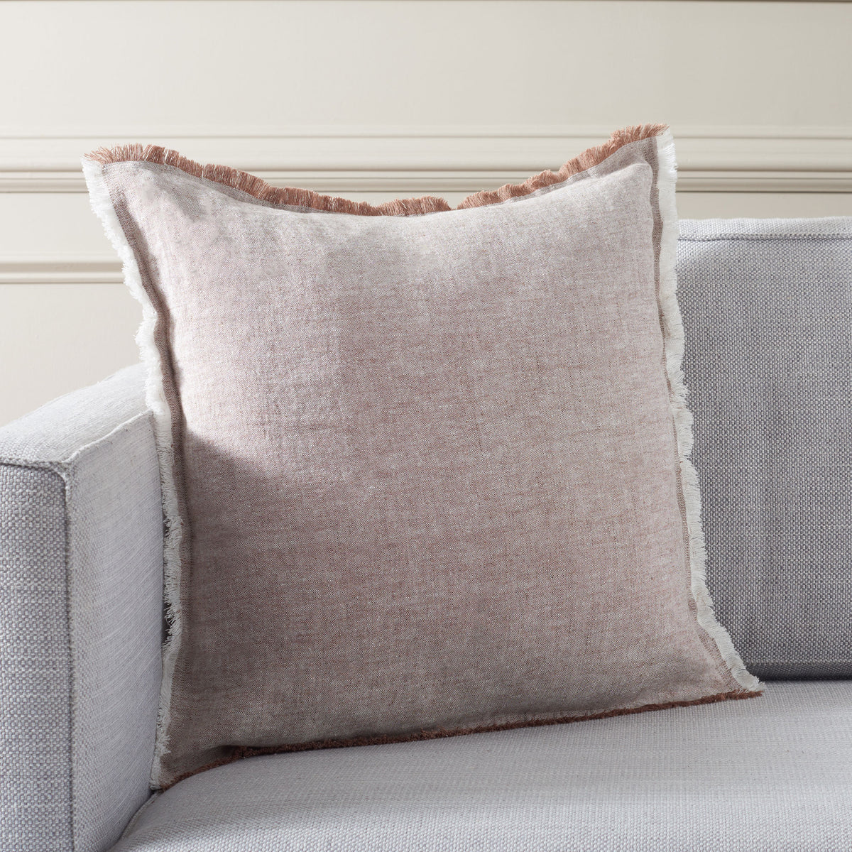 Soft blush linen and contrasting fringe bring warmth to a neutral sofa || PLS8006A-2020 || front_room