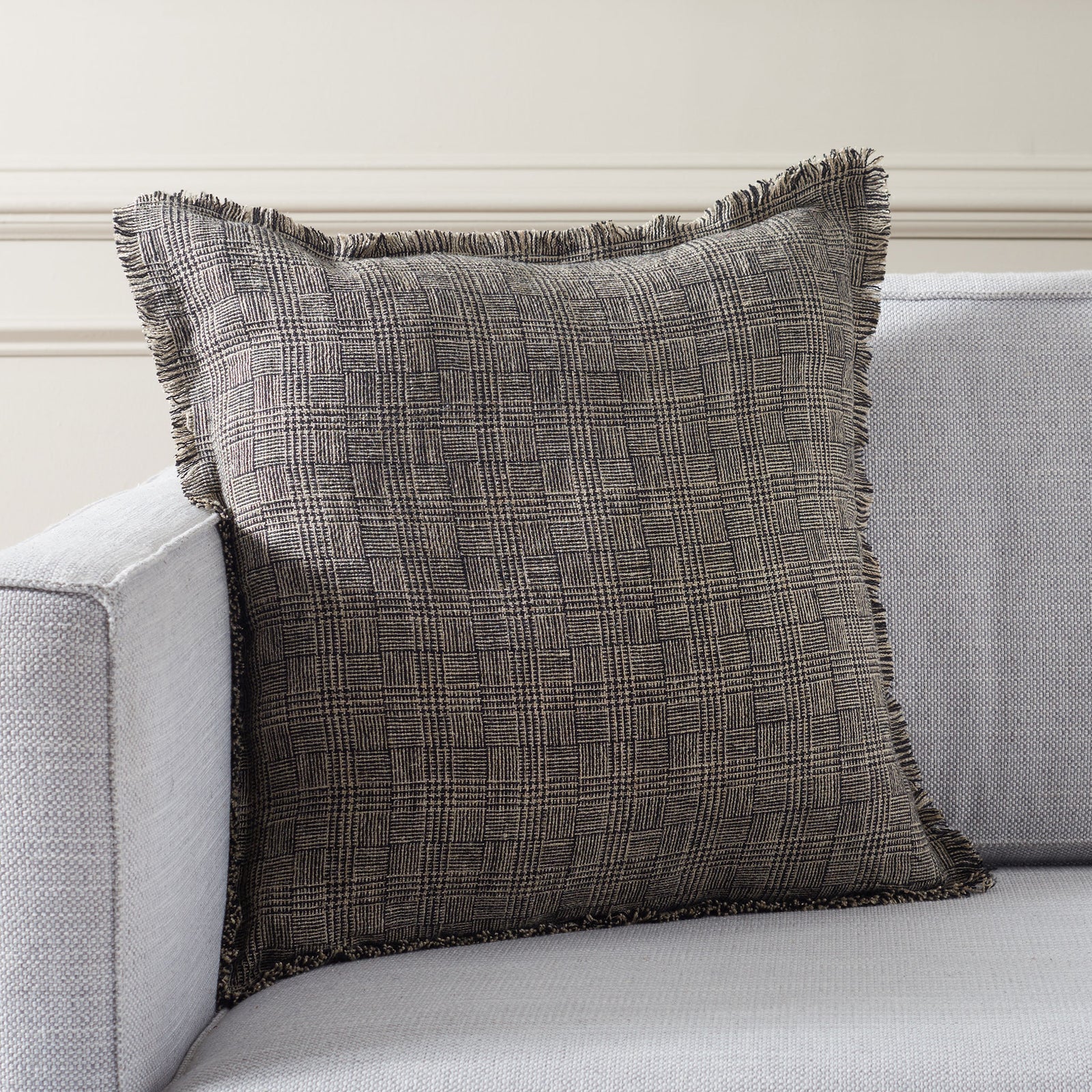 Fringed black and natural pillow adds tactile woven texture to a neutral sofa || PLS8009A-2020 || front_room