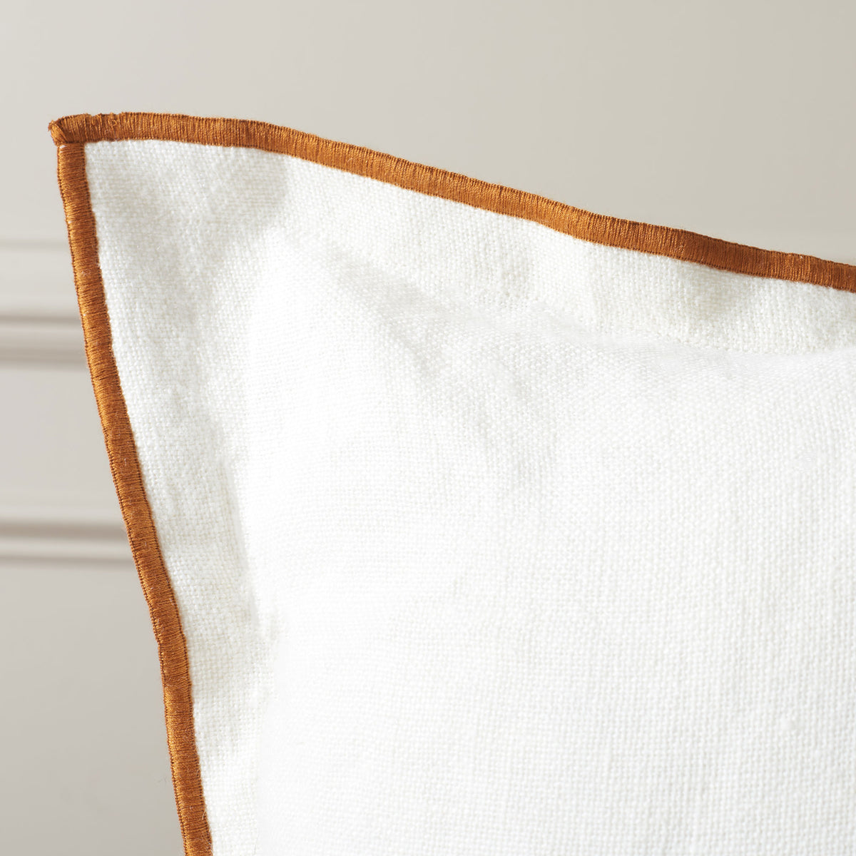 Rust-colored piping highlights the softly textured white linen fabric. || PLS8010A-2020 || detail_room