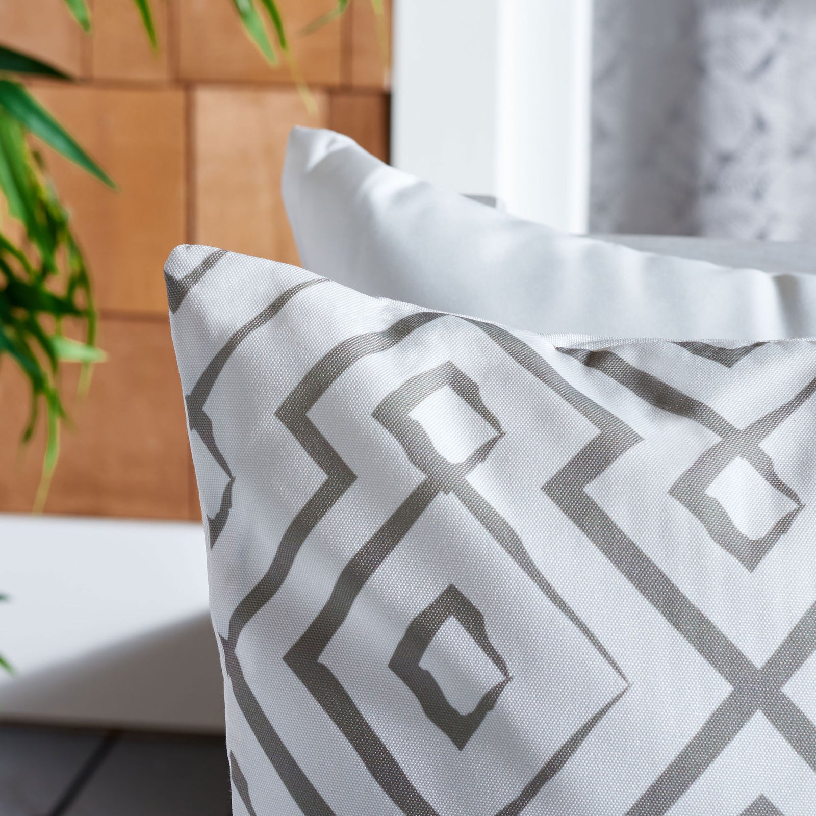 Gray geometric lines trace across the textured white fabric of this outdoor pillow. || PPL260B-1818 || detail_room