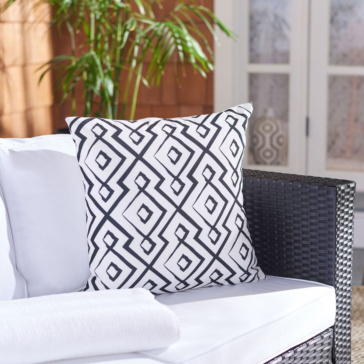 Interlocking black diamonds bring crisp contrast to this plush outdoor accent pillow.