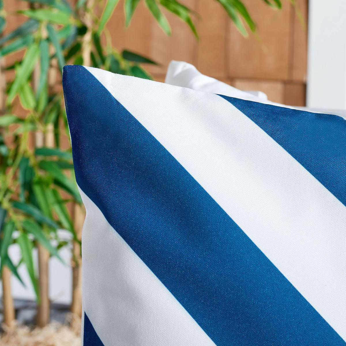 Deep navy and white stripes showcase the pillow's textured fabric weave. || PPL262C-1818 || detail_room