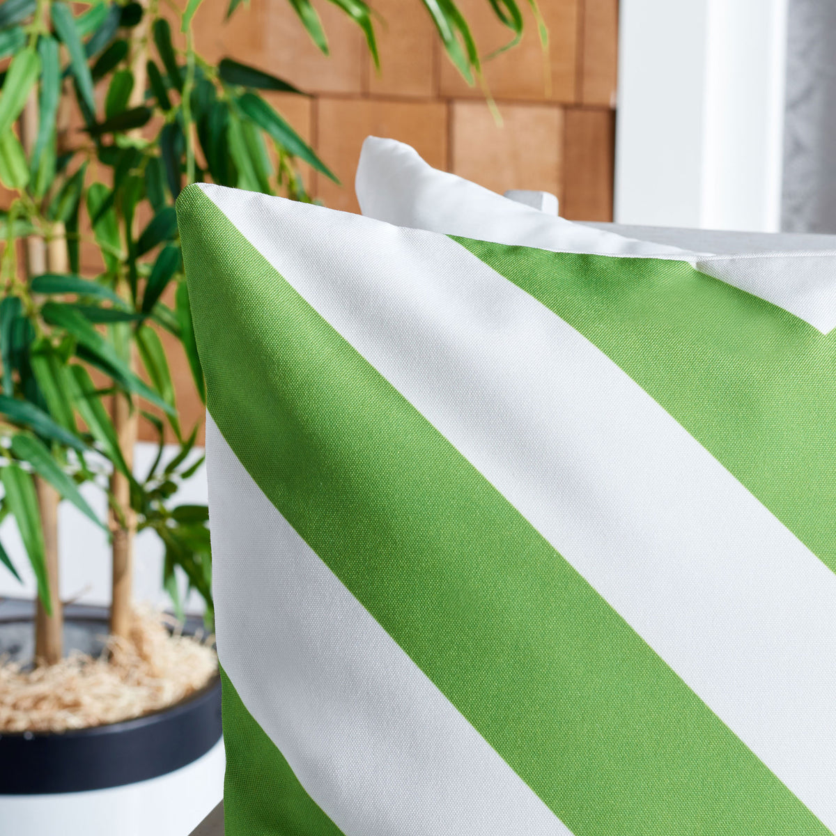 Bright green and white diagonal bands highlight the pillow's woven texture.