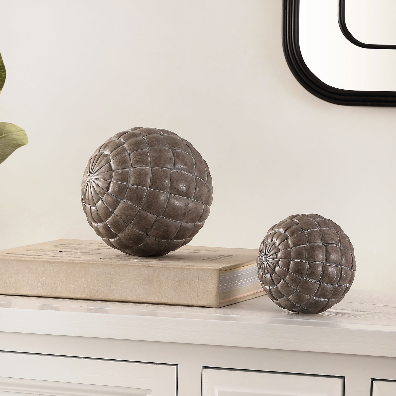 Two dark decorative spheres with raised geometric patterns add sculptural texture to a console || RDC1200A-SET2 || front_room