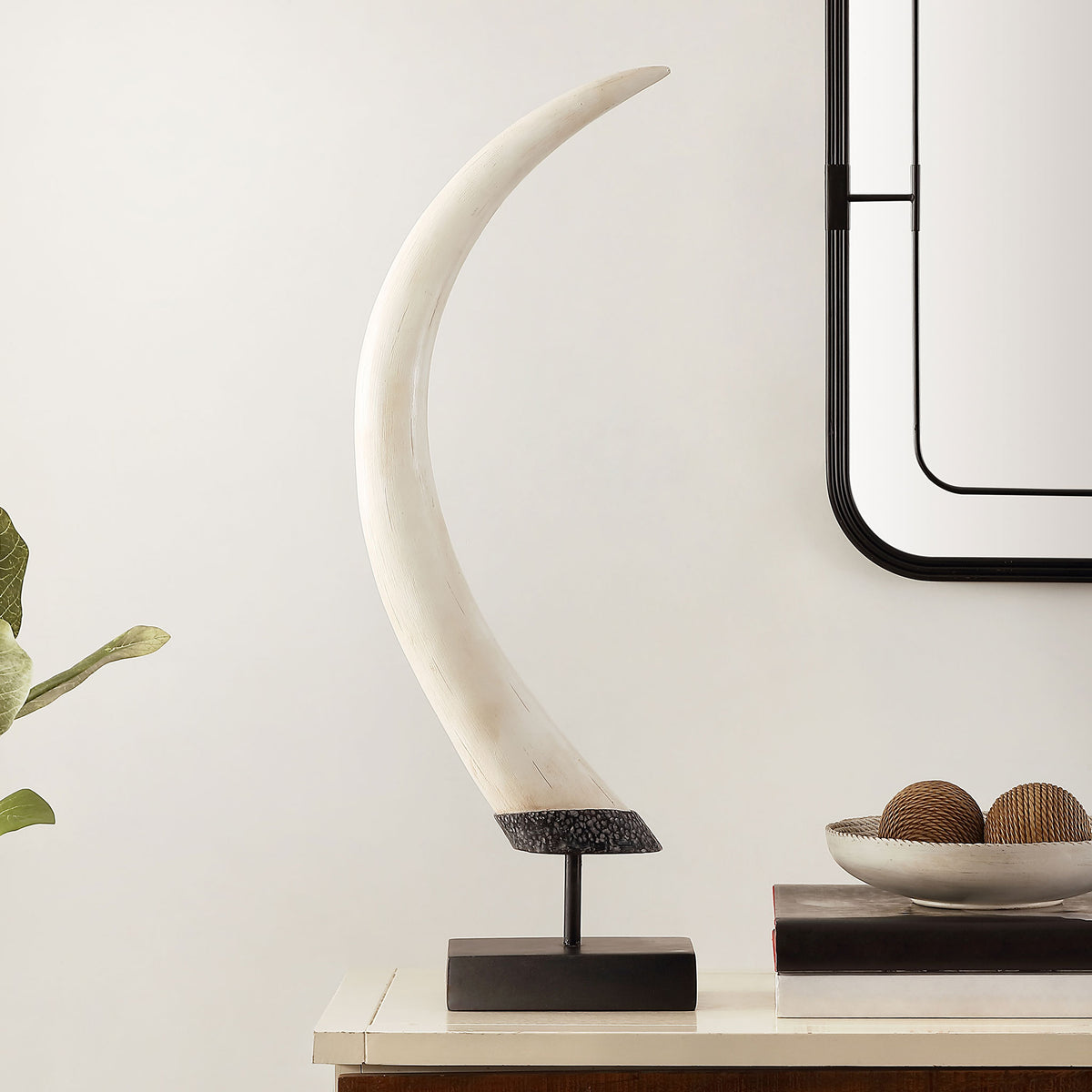A tall, curved white sculpture on a slim black stem and rectangular base adds an artful touch to a console. || RDC1203A || front_room