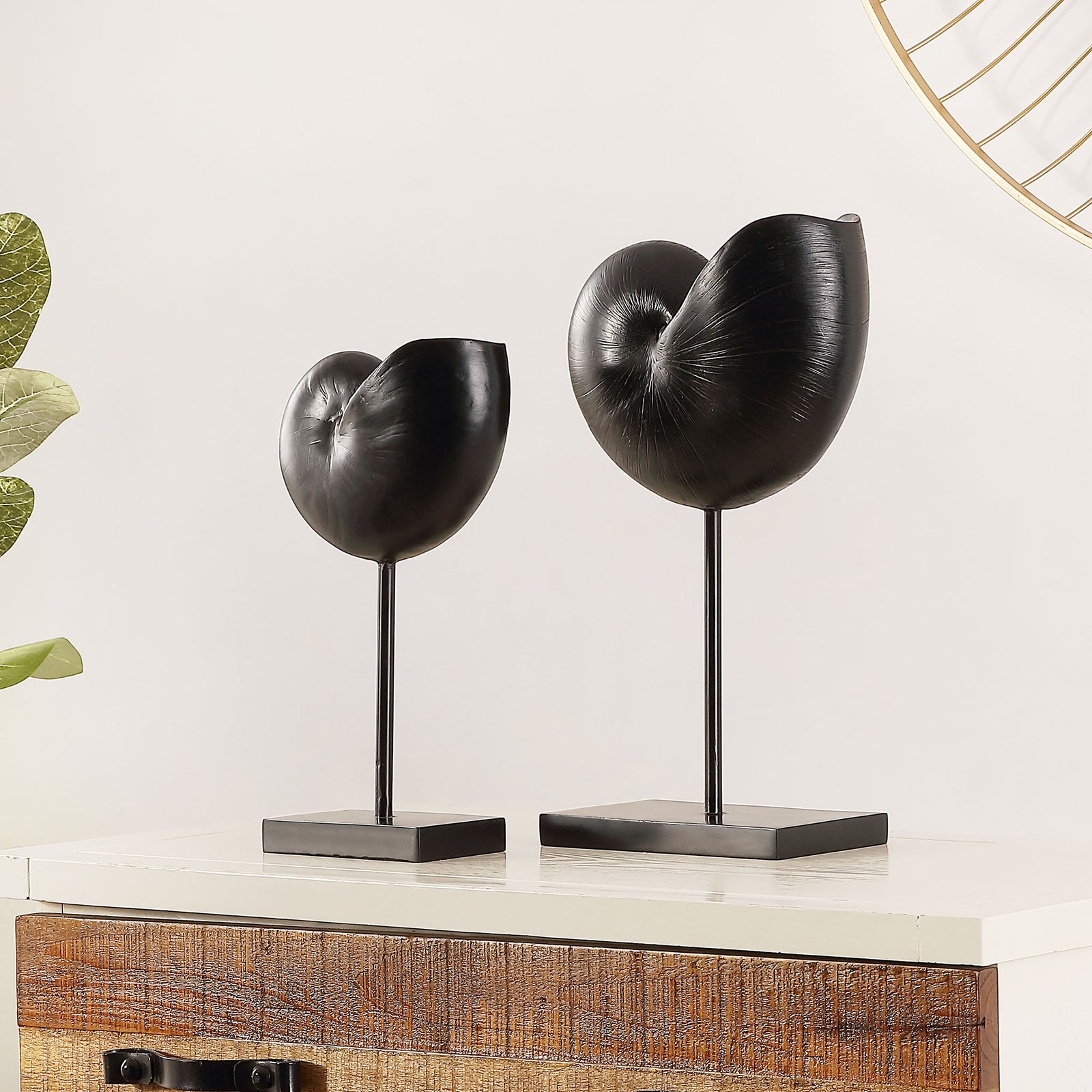 Black snail shell sculptures bring artful contrast to a console with their curved forms and slender stems. || RDC1204A-SET2 || front_angle_room
