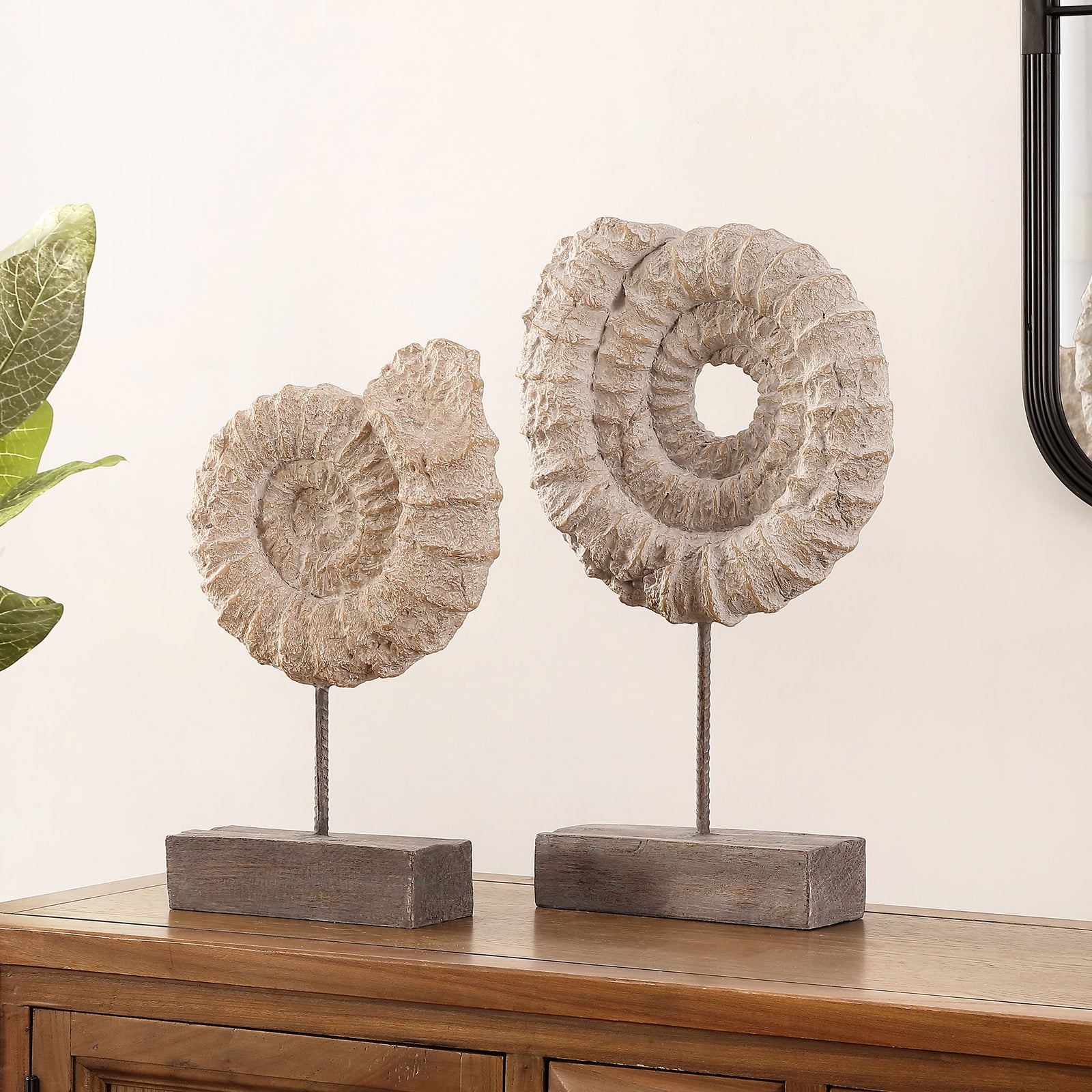 Two textured spiral shell sculptures on dark bases bring organic character to a wood console. || RDC1208A-SET2 || front_angle_room