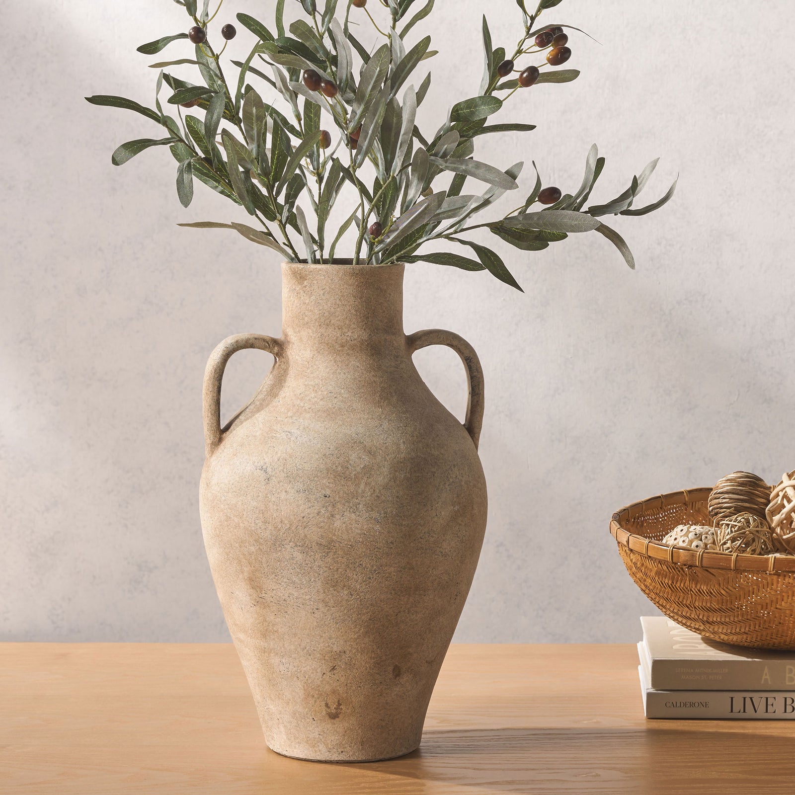 Leafy branches fill a rustic two-handled stoneware vase, bringing natural texture to a tabletop. || RDC1212A || front_room