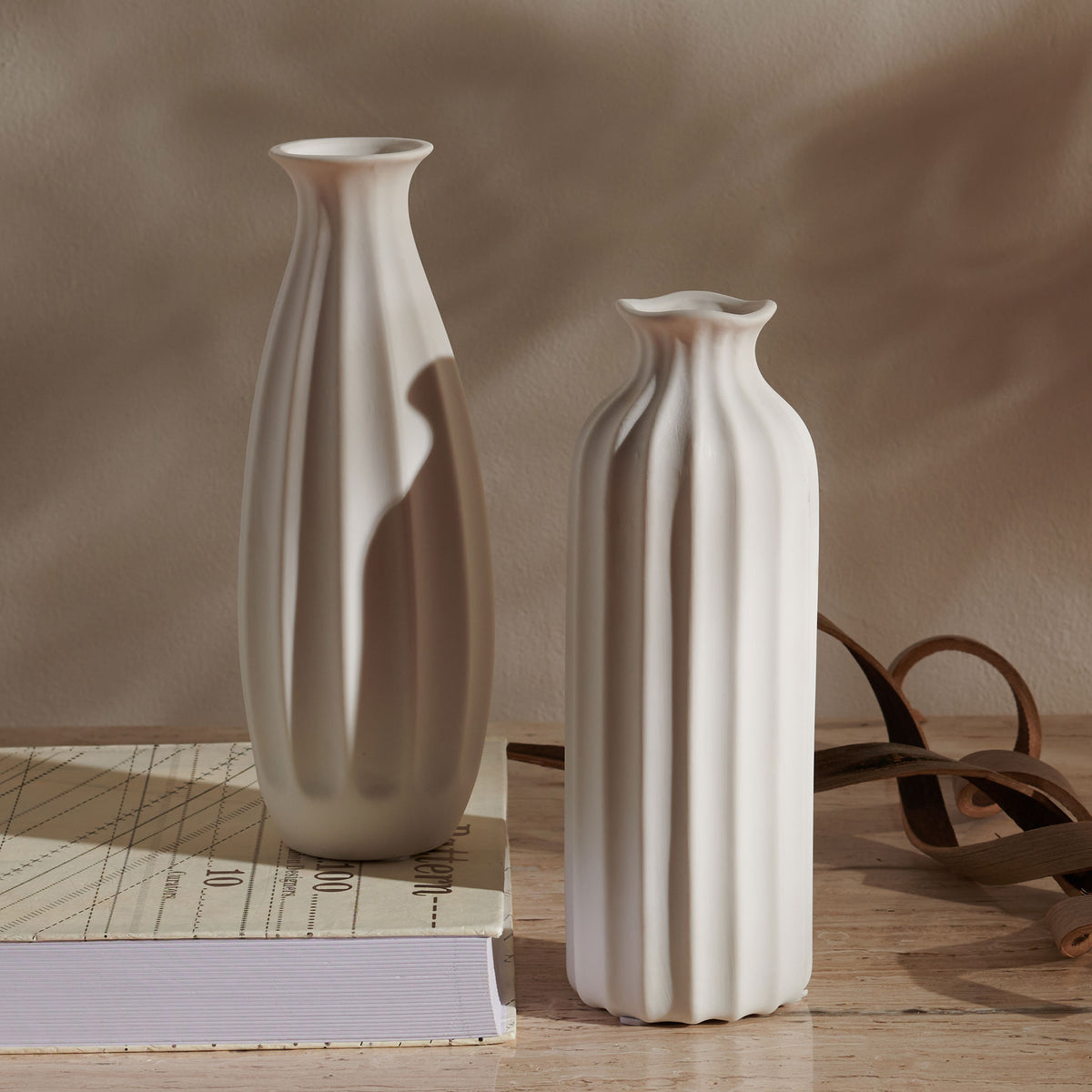 A pair of white fluted ceramic vases adds sculptural texture to a tabletop. || RDC4010A-SET2 || front_room