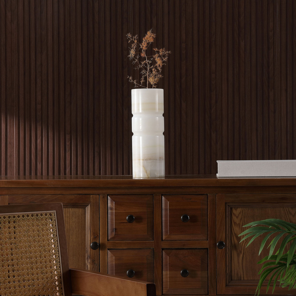 Dried flowers bring sculptural height to an ivory stone vase atop a dark wood credenza || RDC4026A || front_room