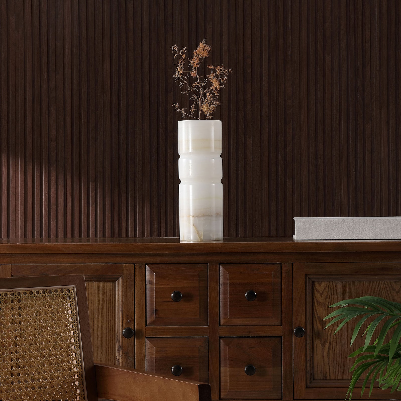 Dried flowers bring sculptural height to an ivory stone vase atop a dark wood credenza || RDC4026A || front_room
