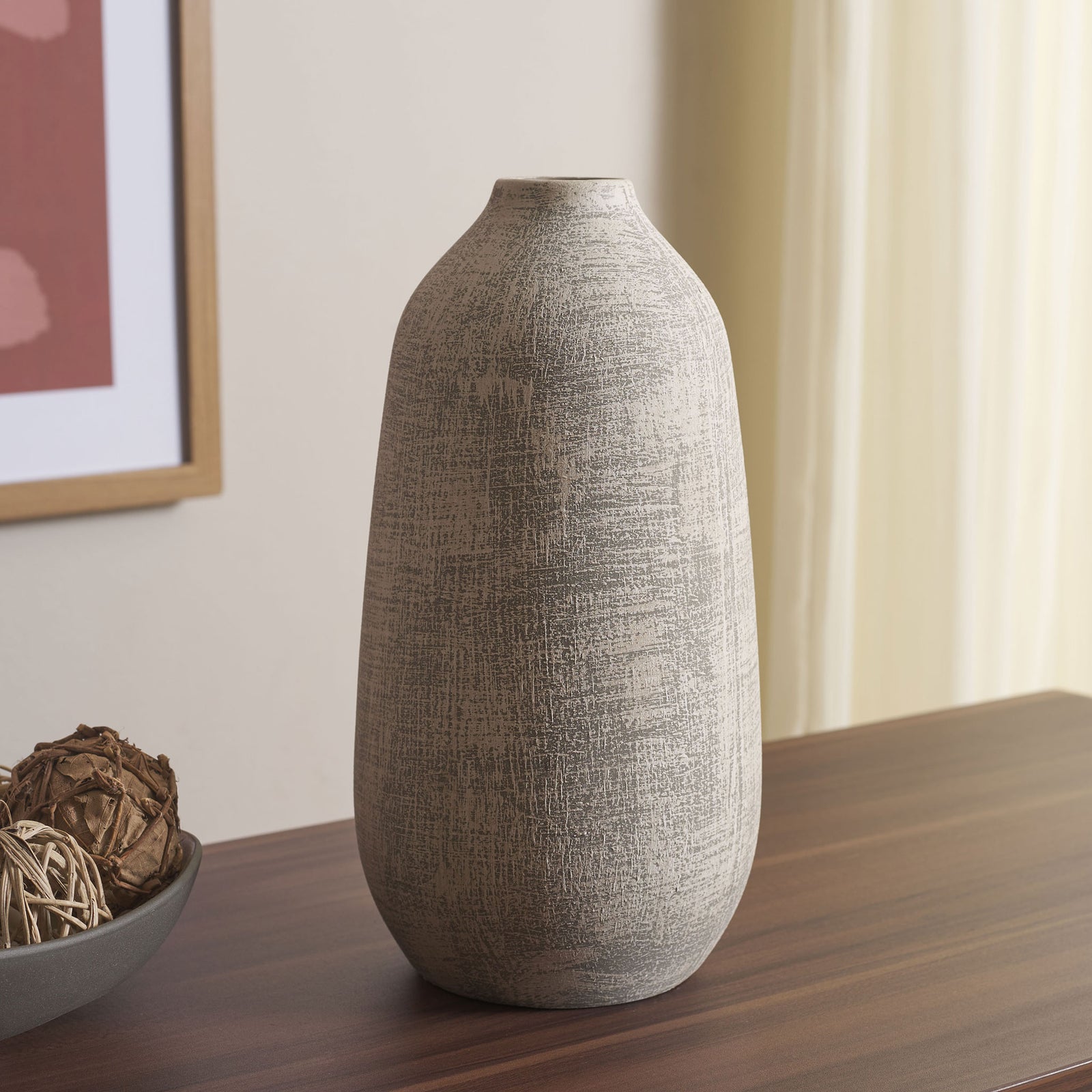 A tapered gray ceramic vase with a weathered whitewash adds earthy texture to a wood tabletop || RDC4031A || front_angle_room