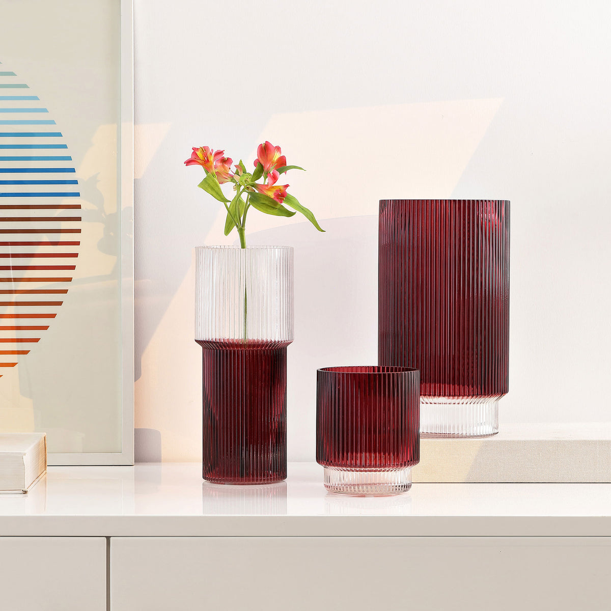 Cranberry glass vases brighten a console with ribbed texture and an airy floral arrangement. || RDC4034B-SET3 || front_angle_room