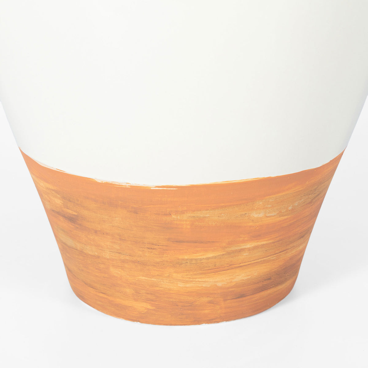 A warm, textured light brown base grounds the vase's smooth ivory ceramic body. || RDC4062A || leg_studio