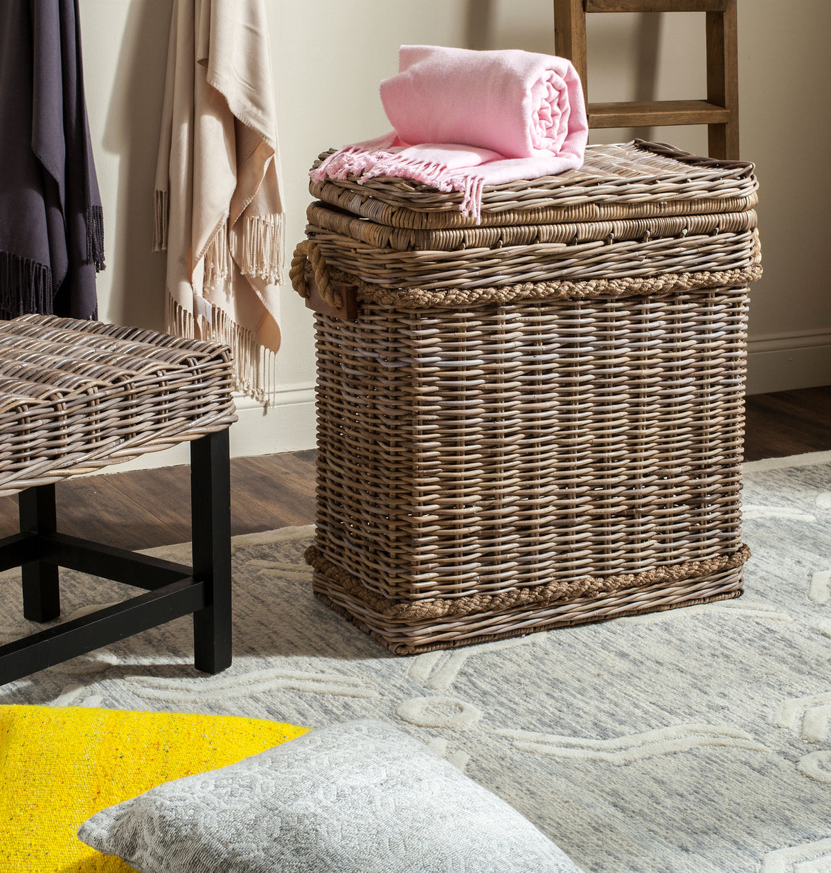 Folded pink linens top a soft gray woven hamper that adds relaxed texture to the room || SEA7020A || front_angle_room